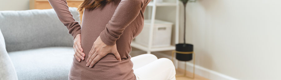 holding lower back at home