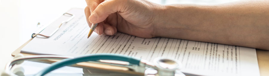 hand with pen on paperwork
